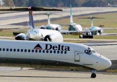 
A Delta Air Lines jet passes a line of jets waiting to take off on the tarmac at Hartsfield-Jackson Atlanta International Airport.  Associated Press
 (Associated Press / The Spokesman-Review)