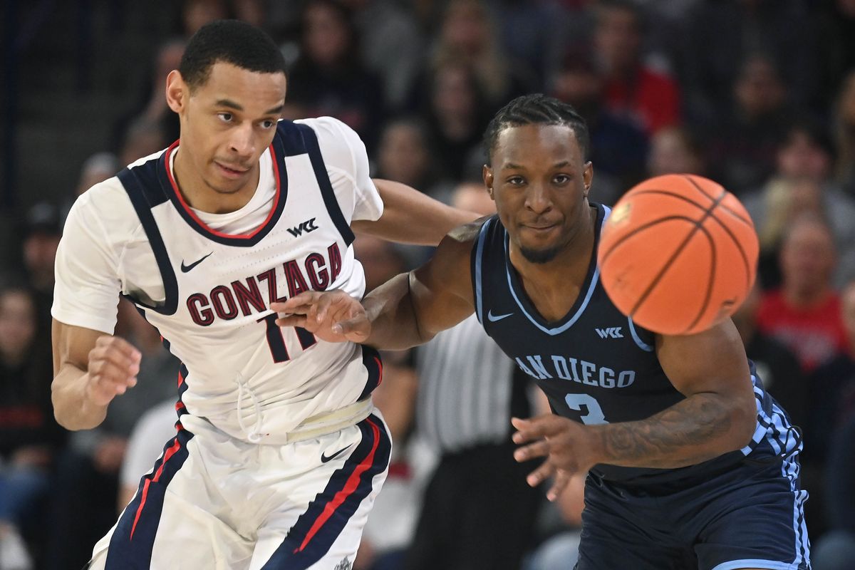 Gonzaga guard Nolan Hickman (11) and San Diego guard Wayne McKinney III (3) chase a loose ball during the first half of a NCAA college basketball game, Thursday, Feb. 23, 2023, in the McCarthey Athletic Center.  (COLIN MULVANY/THE SPOKESMAN-REVIEW)