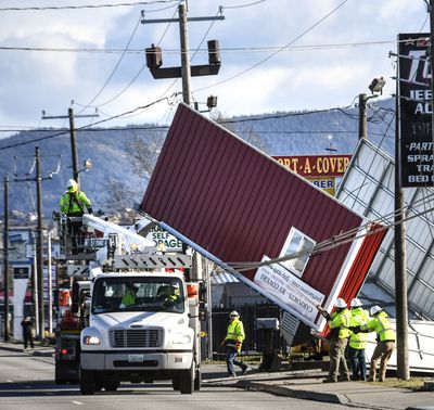 Crews work to free a carport blown into power and cable lines on the 16660 block of East Sprague in Spokane Valley, Wash., after high winds hit the area, Wednesday, Jan. 13, 2021,  (DAN PELLE/THE SPOKESMAN-REVIEW)