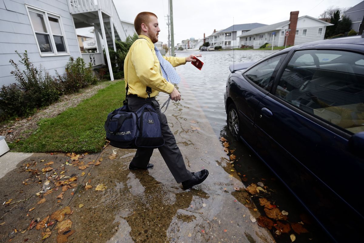 Cody Billotte walks through the high water as he gets in his car to go to work as Hurricane Sandy bears down on the East Coast, Sunday, Oct. 28, 2012, in Ocean City, Md. Governors from North Carolina, where steady rains were whipped by gusting winds Saturday night, to Connecticut declared states of emergency. Delaware ordered mandatory evacuations for coastal communities by 8 p.m. Sunday. (Alex Brandon / Associated Press)