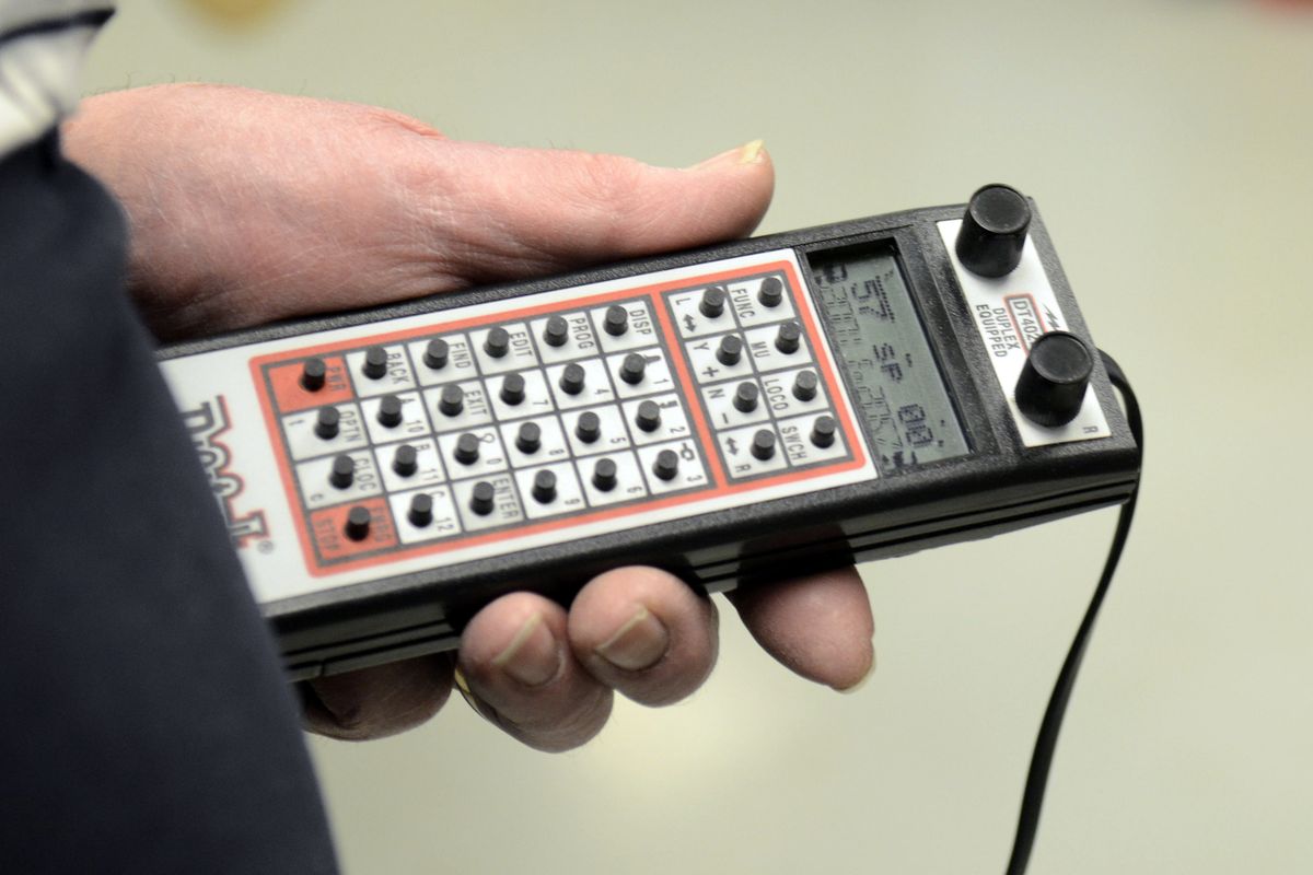 John Langlot holds a modern train controller, which can be plugged in at several points along the elaborate layout of the River City Modelers in Spokane Friday. (Jesse Tinsley)