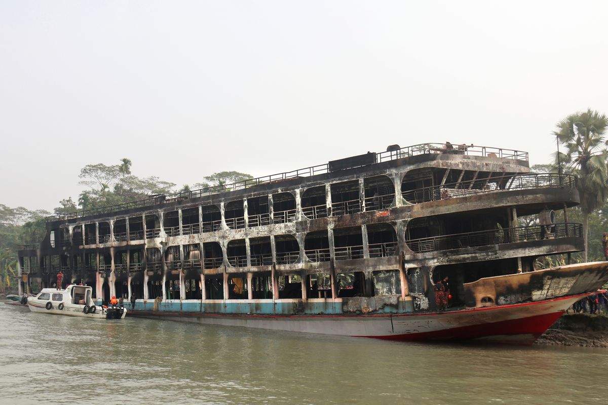 A burnt passenger ferry is seen anchored off the coast of Jhalokati district on the Sugandha River in Bangladesh, Friday, Dec. 24, 2021. Bangladesh fire services say at least 37 passengers have been killed and many others injured in a massive fire that swept through a ferry on the southern Sugandha River. The blaze broke out around 3 a.m. Friday on the ferry packed with 800 passengers.  (STR)