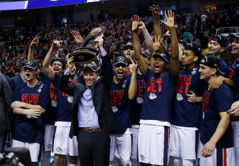Gonzaga head coach Mark Few, center, holds a trophy with his team after beating Xavier during an NCAA Tournament college basketball regional final game Saturday, March 25, 2017, in San Jose, Calif. (AP Photo/Tony Avelar) 