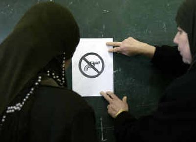
Palestinian election officials place a sign that forbids guns at a classroom to be used as a voting station for today's elections, at a school on Saturday in the West Bank town of Abu Dis in the outskirts of Jerusalem.Palestinian election officials place a sign that forbids guns at a classroom to be used as a voting station for today's elections, at a school on Saturday in the West Bank town of Abu Dis in the outskirts of Jerusalem.
 (Associated PressAssociated Press / The Spokesman-Review)