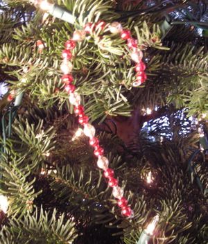 A glass candy cane makes old garland into a new ornament. (Maggie Bullock)