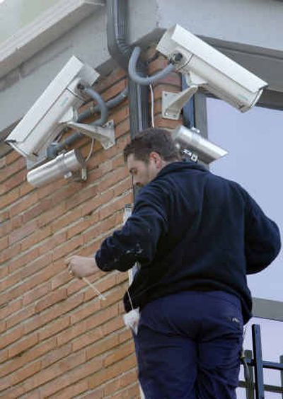 
A worker installs security cameras on a wall of a courthouse in the Casa del Campo park Thursday in Madrid. 
 (Associated Press / The Spokesman-Review)