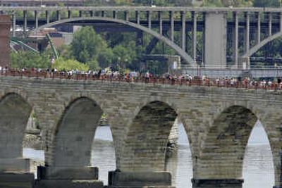 
People line the Stone Arch Bridge as they look away from the camera at the I-35W bridge collapse site in Minneapolis on Sunday. Associated Press
 (Associated Press / The Spokesman-Review)