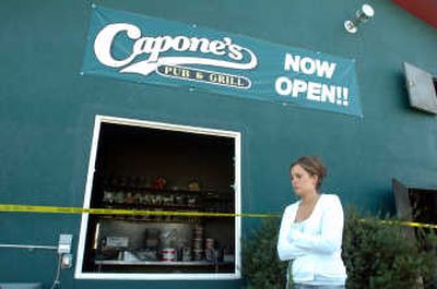
Mandi Oldmixon, an employee at Capone's Pub and Grill in Post Falls, walks outside the bar, which was gutted by fire early Wednesday. 
 (Jesse Tinsley / The Spokesman-Review)