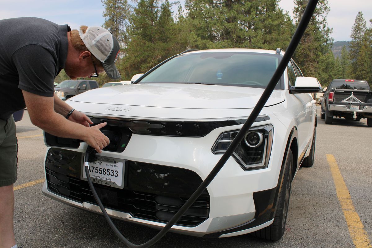 Brandon Hansen, resident of Chewelah, plugs in his Kia Niro to charge at the Chewelah Golf and Country Club. Hansen switched to an electric vehicle earlier this year after being impressed on a test-drive.  (Monica Carrillo-Casas/The Spokesman-Review)