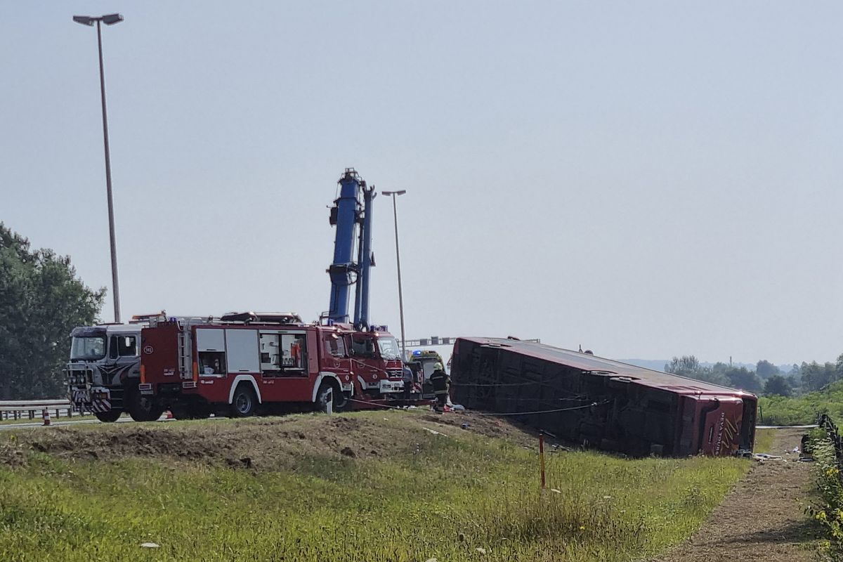 Emergency crews work at the site of a bus accident near Slavonski Brod, Croatia, Sunday, July 25, 2021. A bus swerved off a highway and crashed in Croatia early Sunday, killing 10 people and injuring at least 30 others, police said.  (Luka Safundzic)