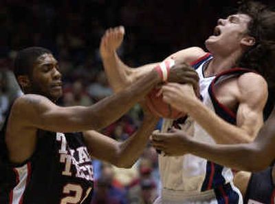 Texas Techs Devonne Giles, left, ties up Gonzagas Adam Morrison in the first half of Saturdays game in Tucson, Ariz. Morrison led the Bulldogs with 25 points.
 (Dan Pelle / The Spokesman-Review)