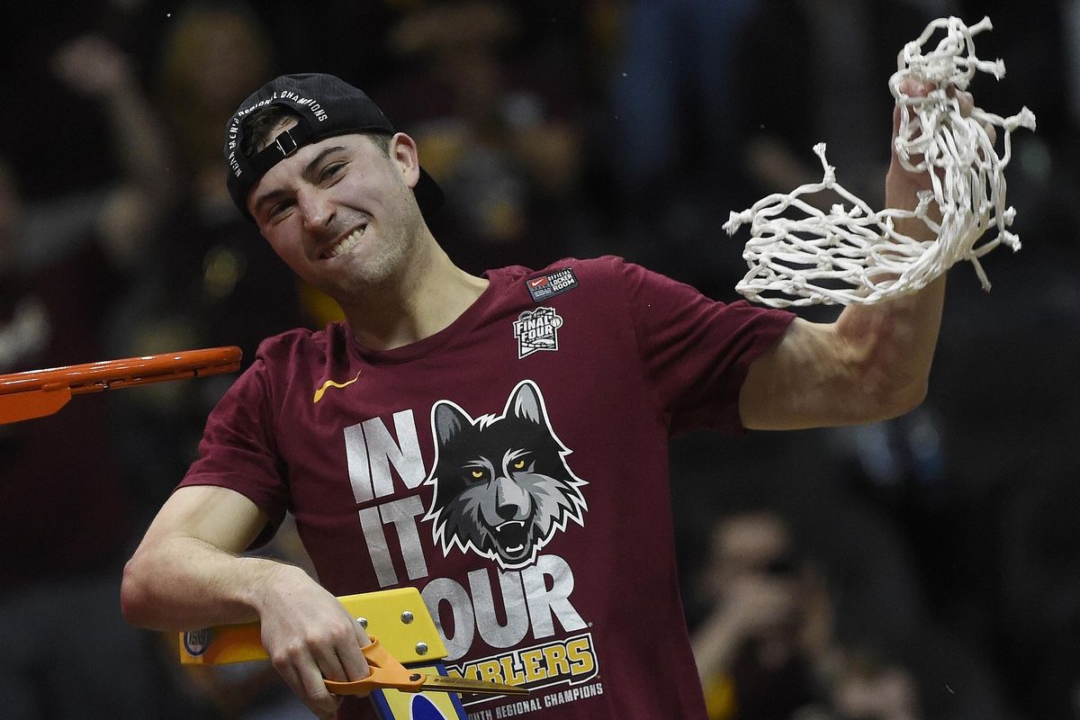 Loyola-Chicago guard Ben Richardson holds the net after a regional final NCAA college basketball tournament game against Kansas State, Saturday, March 24, 2018, in Atlanta. Loyola-Chicago won 78-62. (John Amis / Associated Press)