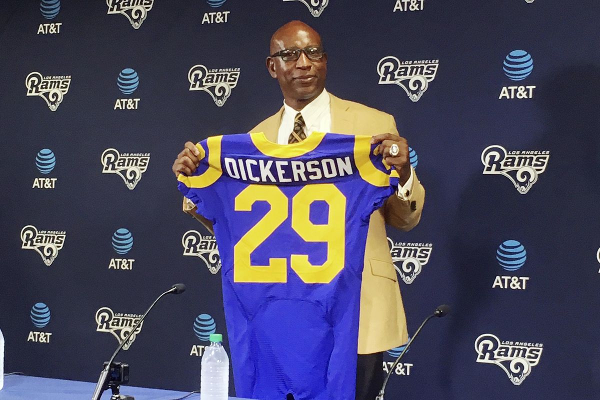 Eric Dickerson poses with his "new"jersey after he signed a one-day contract to retire as a member of the Los Angeles Rams, reuniting the famous running back with his first NFL football franchise, at the team