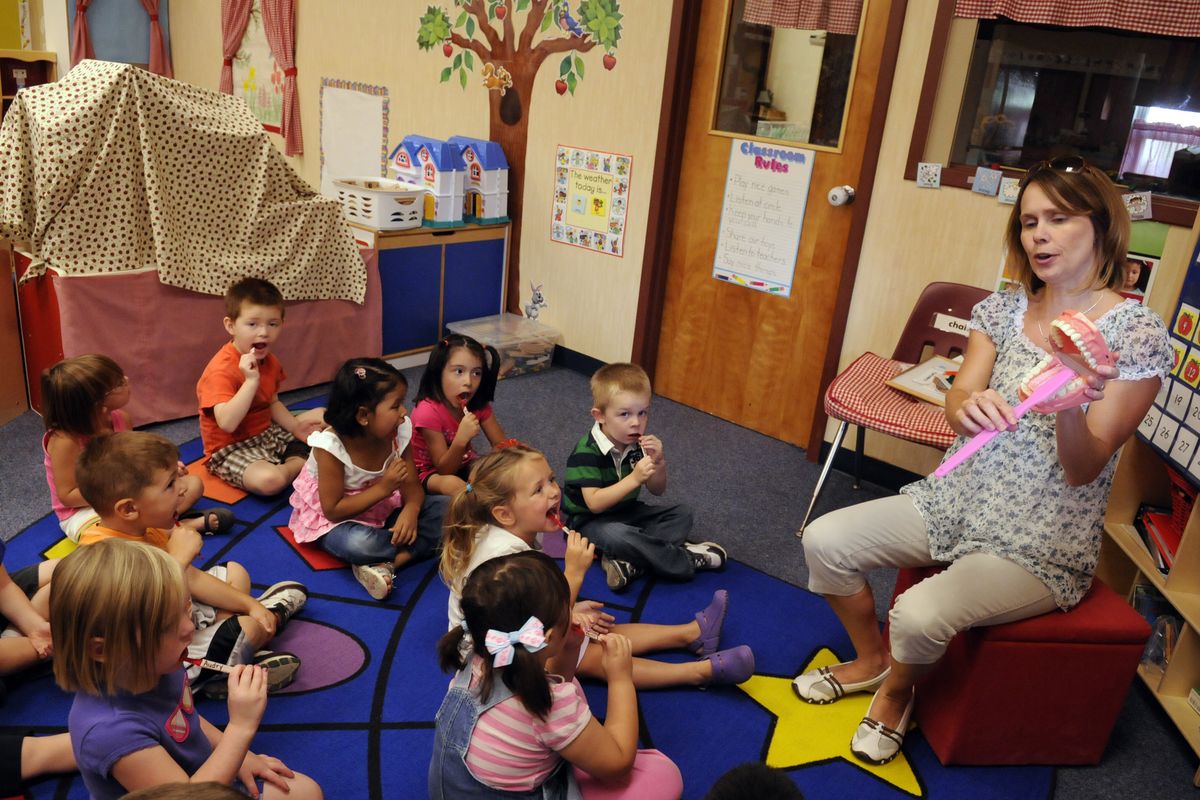 Teacher Casey Lee demonstrates with a model mouth how to brush teeth after handing out toothbrushes to her ECEAP class at the Central Valley Early Learning Center on Monday. (J. Bart Rayniak)