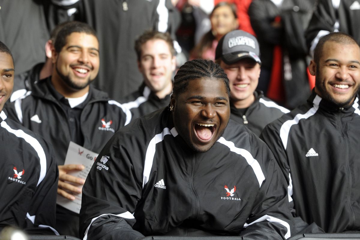 Renard Williams, center, laughs with teammates watching interviews on stage during a rally at River Park Square on Saturday.  (Jesse Tinsley)