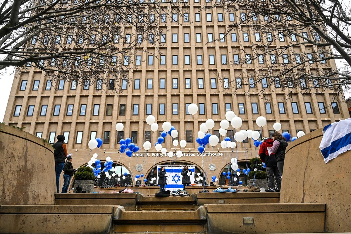Iris Berenstein, left center, and Rabi Tamar Malino read the names of hostages in Gaza during a gathering of the Jewish community at the U.S. Courthouse on Tuesday in downtown Spokane.  (DAN PELLE/THE SPOKESMAN-REVIEW)