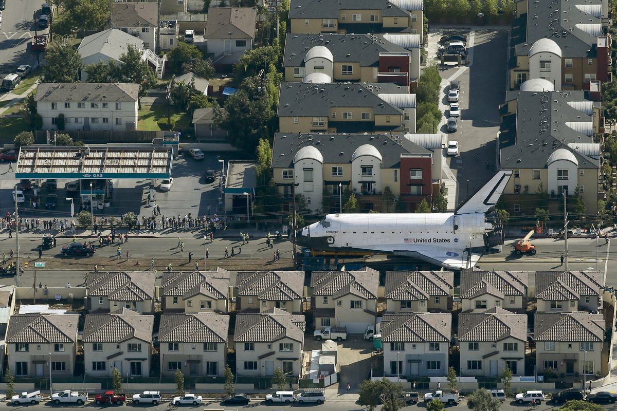 Spectators gather to watch the space shuttle Endeavour make its way down Manchester Blvd. in Los Angeles, Friday, Oct. 12, 2012. Endeavour