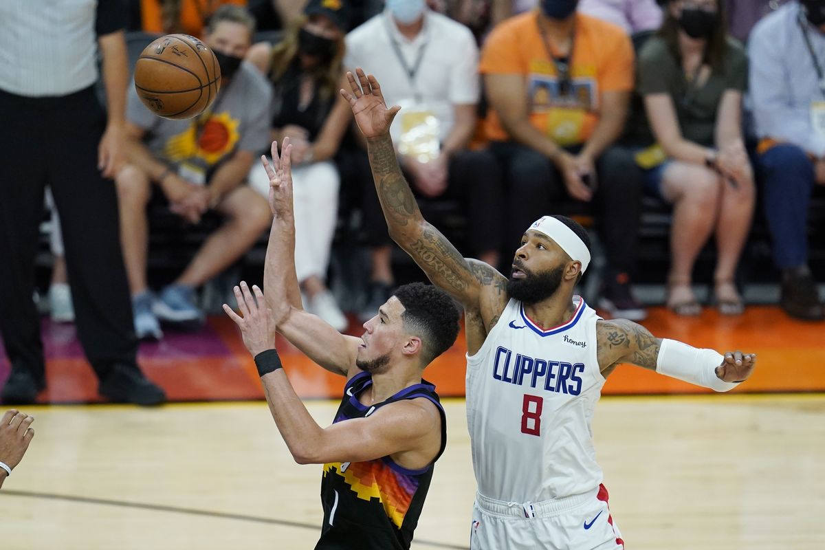 Phoenix Suns guard Devin Booker (1) shoots as he gets past Los Angeles Clippers forward Marcus Morris Sr. (8) during the first half of Game 1 of the NBA basketball Western Conference finals Sunday, June 20, 2021, in Phoenix.  (Ross D. Franklin)
