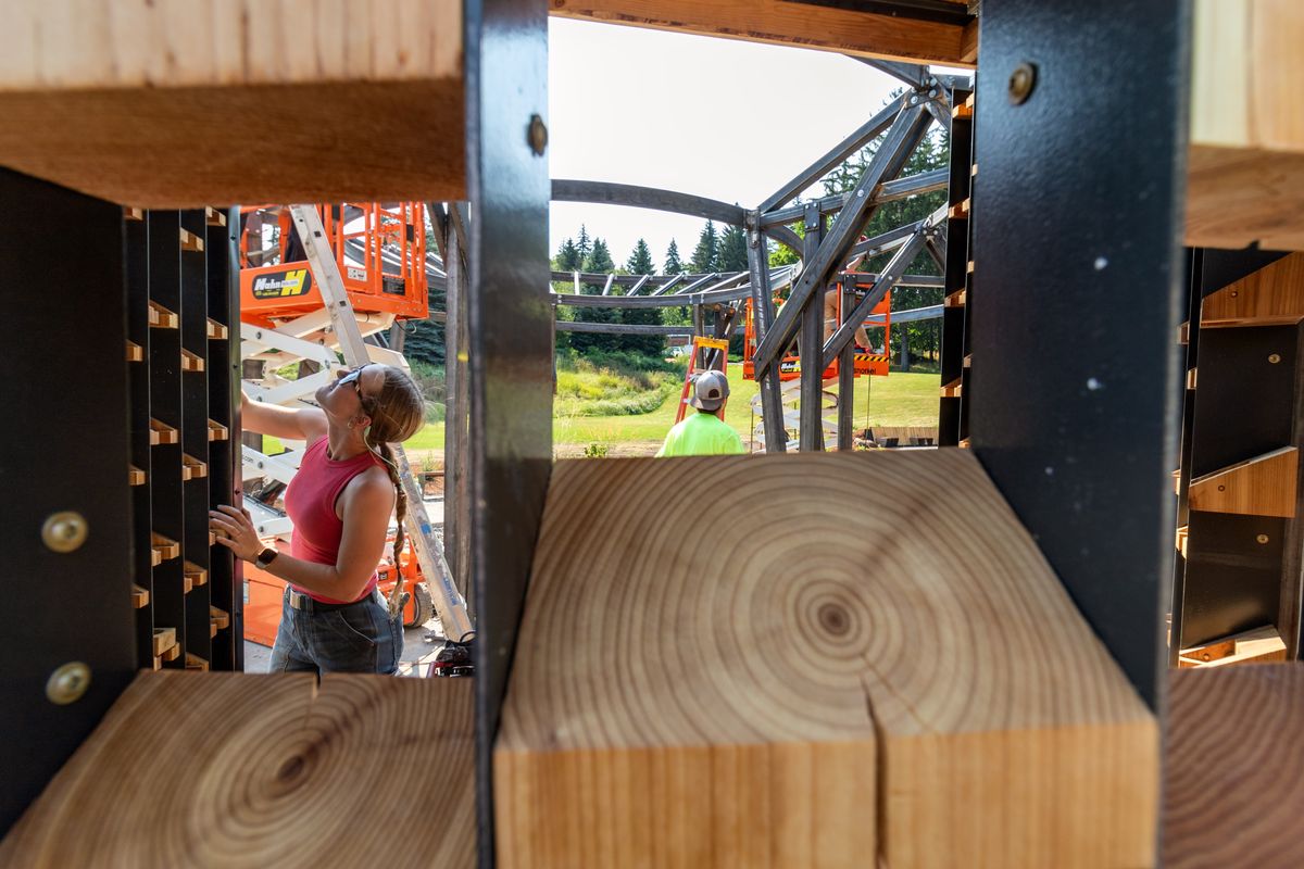Architecture student Harper Drake installs a wooden piece while working on the University of Idaho’s new Healing Garden and Memorial on Friday in Moscow, Idaho.  (Geoff Crimmins/For The Spokesman-Review)