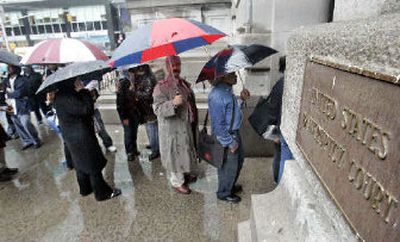 
People wait in line under umbrellas against the rain outside U.S. Bankruptcy Court in New York on Friday. Thousands of consumers across the nation filed bankruptcy petitions Friday in advance of a new law that takes effect Monday.
 (Associated Press / The Spokesman-Review)
