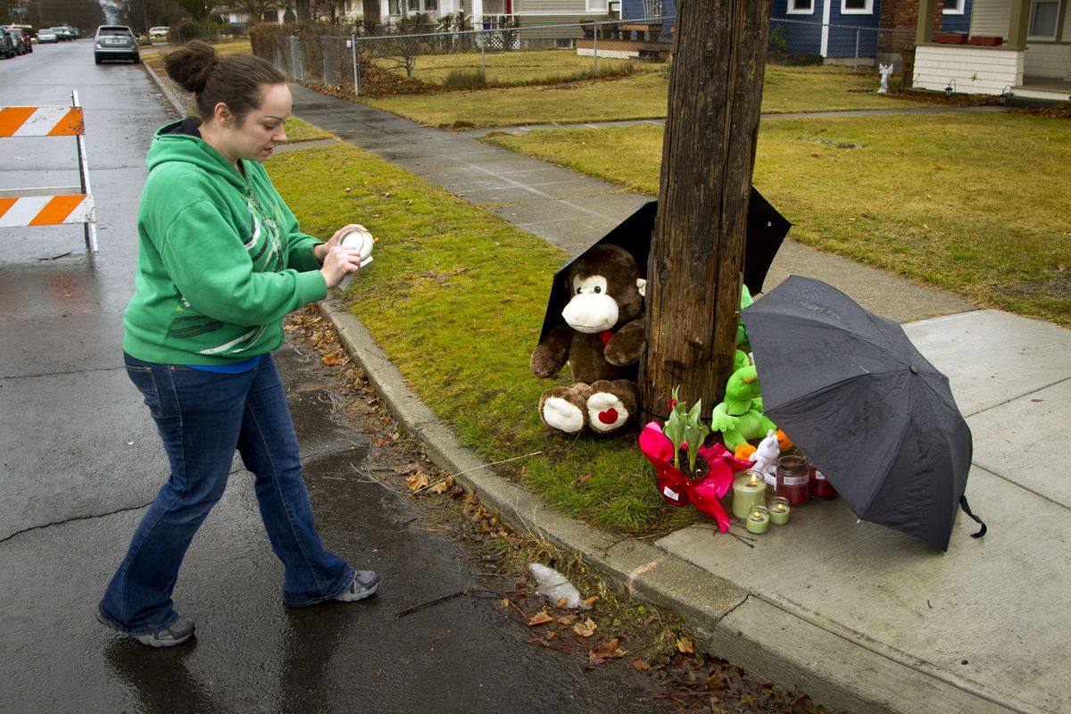 “It’s just so unfortunate,” neighbor Shanda Smith said on Saturday as she placed a lit candle at an impromptu memorial near the scene of the triple homicide at 4411 N. Whitehouse St. (Colin Mulvany)