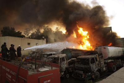 Pakistani firefighters try to extinguish a fire that erupted at the NATO terminal after an alleged militants’ attack Thursday in Peshawar, Pakistan.  (Associated Press / The Spokesman-Review)