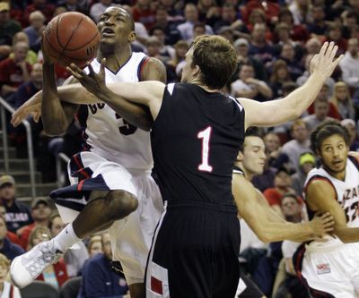 Bulldogs guard Demetri Goodson, left, tangles with Davidson guard Brendan McKillop in the second half Saturday at KeyArena.  (Associated Press)