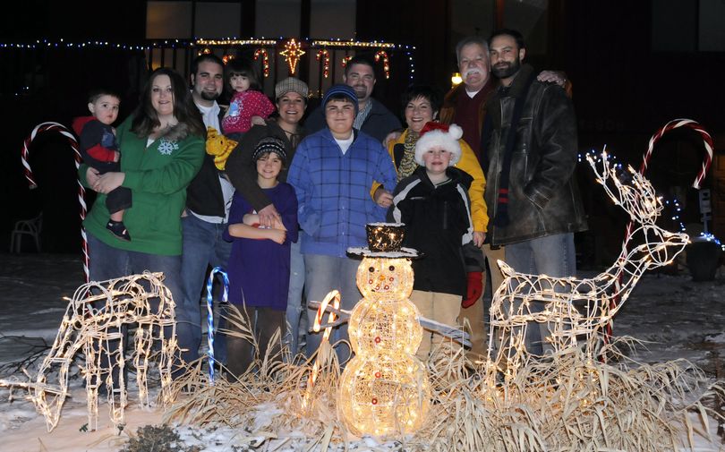 Members of the extended  Hughes family pose for a Christmas portrait in Spokane Valley. From left are  Cohen, 1, Mary, Andrew and Tula Hughes, 2 ; Sam, 8, Nichole,  Max, 11, and Matthew Bergam;  Janice Hughes stands beside her husband, Steve; Ian Hughes, far right, and his son, Hayden, 10, in front. The families recently purchased new homes with three of them swapping homes with other family members. (J. BART RAYNIAK)