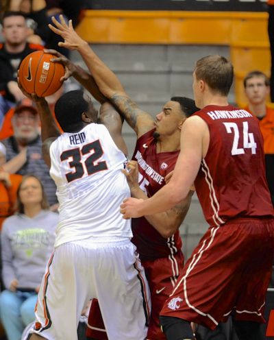 WSU’s Josh Hawkinson, right, and DaVonte Lacy defend against OSU’s Jarmal Reid. (Associated Press)