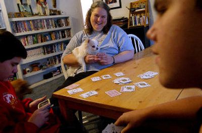 
Cheryl Pounds plays cards Wednesday with two of her adopted sons, Chad Pounds, left, and Steven Pounds, at their home in Blanchard, Idaho. Cheryl and her husband, Gary, have adopted five children since 1999, three of them as teenagers. Cheryl Pounds will speak at the Adoption Information Night planned Tuesday at Kootenai Medical Center. 
 (Kathy Plonka / The Spokesman-Review)