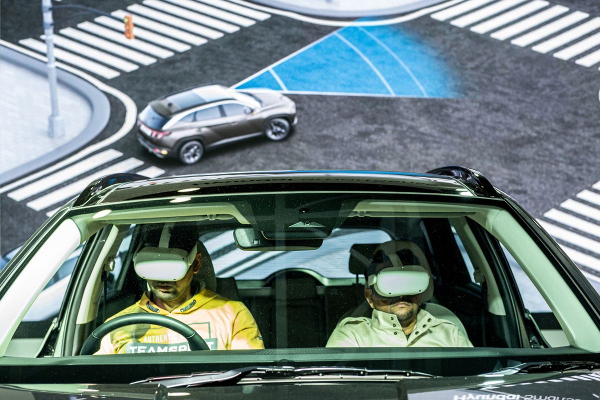 Visitors wearing VR devices experience a virtual drive Jan 13 at the Hyundai Motor Co. booth at the India Auto Expo 2023 in Noida India.  (Anindito Mukherjee/Bloomberg)