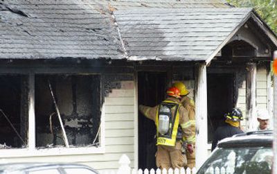 
A firefighter enters a home destroyed by fire Monday in Kirkland. 
 (Associated Press / The Spokesman-Review)
