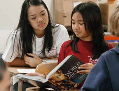 
Eighth-graders Millie Phimmasone, right, and Lucky Sayabanha, look at a history book at Fairmont Junior High School in Boise. 
 (Associated Press / The Spokesman-Review)