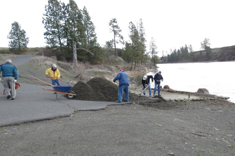 Gravel is spread by muscle power at the Amber Lake boat access by members of the Inland Empire and Spokane fly fishing clubs on Feb. 25, 2016. (Jim Ahearn)