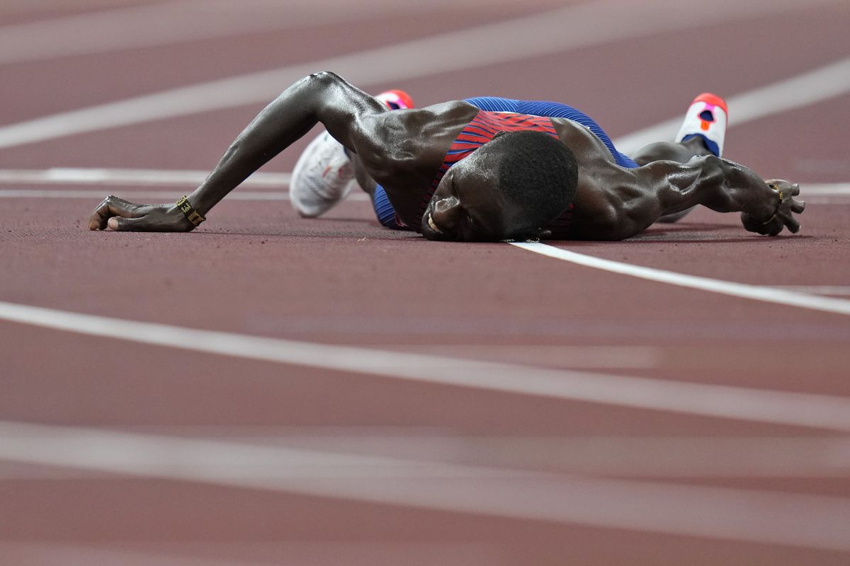 In this Aug. 6, 2021, file photo, Paul Chelimo, of United States, lies on the track after the final of the men