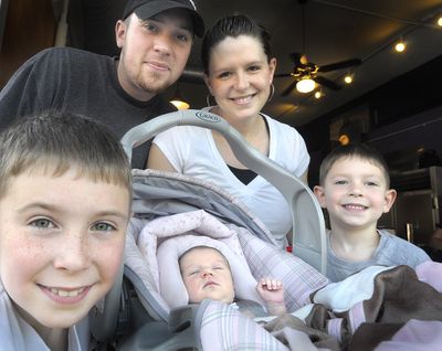 Olivia Emery  came into the world at eight minutes past midnight on the eighth day of the eighth month. She is surrounded Tuesday by her family, from left, brother Dawson Emery, father Reid Emery, mother Krista Murphy and brother Cole Emery.  (CHRISTOPHER ANDERSON / The Spokesman-Review)
