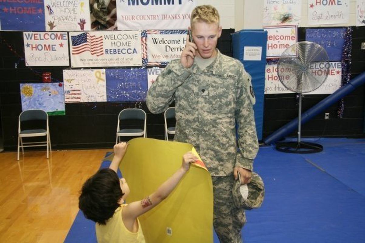 Aaron Torrey encounters a 4-year-old girl holding a sign saying “Welcome Home Sweetheart” upon his arrival in Fort Lewis.Photo courtesy of Meg Torrey (Photo courtesy of Meg Torrey / The Spokesman-Review)