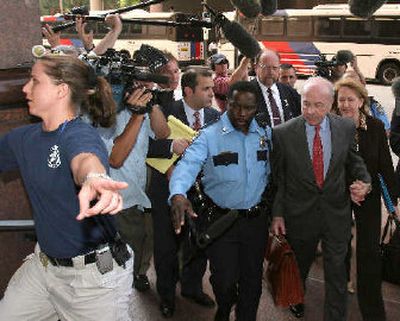 
Law enforcement officials escort Enron founder Kenneth Lay and his wife Linda away from the courthouse Monday. 
 (Associated Press / The Spokesman-Review)