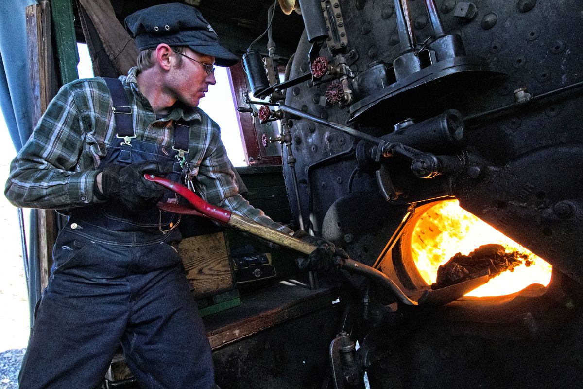 Con Trumbull, the archivist and trainmaster of the Nevada Northern Railway, shovels a load of coal into the firebox of locomotive No. 40.  (Justin Franz/For the Washington Post)