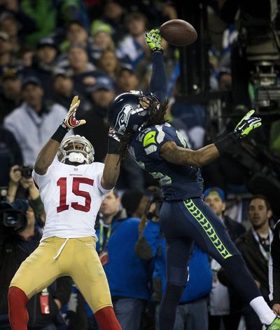 Seattle Seahawks cornerback Richard Sherman makes “The Tip” against San Francisco 49ers wide receiver Michael Crabtree, clinching the 2014 NFC championship for the Seahawks on Jan. 19, 2014.  (Tribune News Service)