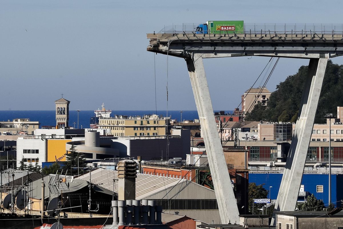 A view of the Morandi highway bridge that collapsed in Genoa, northern Italy, Wednesday, Aug. 15, 2018. A large section of the bridge collapsed over an industrial area in the Italian city of Genova during a sudden and violent storm, leaving vehicles crushed in rubble below. (Antonio Calanni / Associated Press)