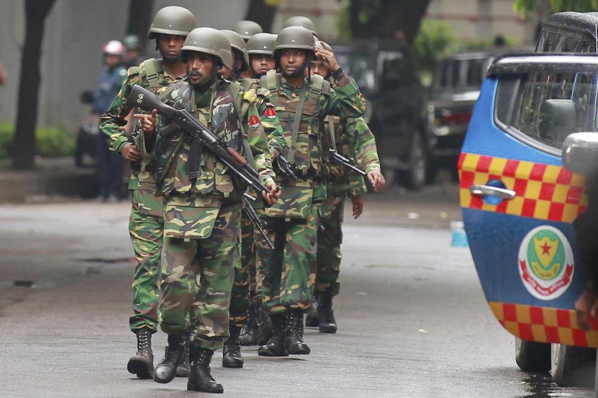 Bangladeshi soldiers come out of an area housing a restaurant popular with foreigners Saturday after heavily armed militants attacked it on Friday night and took dozens of hostages, in a diplomatic zone of the Bangladeshi capital Dhaka, Bangladesh. The Islamic State group claimed responsibility for the attack on the Holey Artisan Bakery in Dhaka