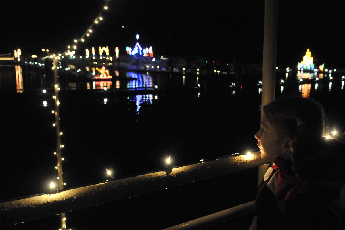May Larsen, 8, sits by the rail and watches the lights as a Coeur d’Alene Cruises tour boat leaves the Coeur d’Alene Resort marina on Tuesday for a preview cruise for media and local dignitaries. The annual Holiday Light Show kicks off the day after Thanksgiving. (Jesse Tinsley)