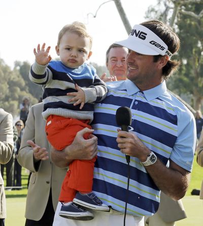 Bubba Watson holds his son after winning at Riviera CC. (Associated Press)