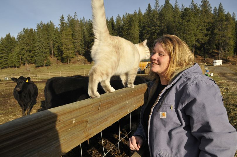 Collette Bise, who raises Angus beef on a farm near Newman Lake, nuzzles Fluffy, one of the farm cats, Nov. 16. Her dog, Tibby, was shot and killed nearby on Oct. 25. (Jesse Tinsley)