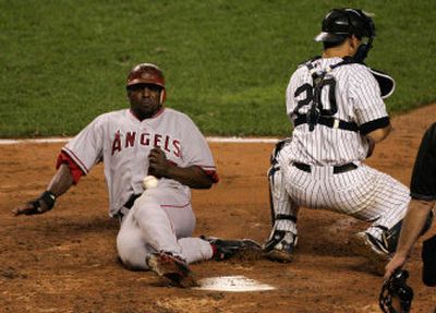 
Los Angeles Angels' Vladimir Guerrero slides safely into home as the ball gets by New York Yankees catcher Jorge Posada.
 (Associated Press / The Spokesman-Review)