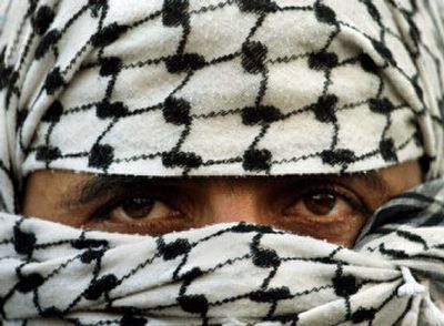 
A Palestinian militant looks out from his mask during a demonstration outside the Fatah Party headquarters in Gaza City on Wednesday.
 (Associated Press / The Spokesman-Review)
