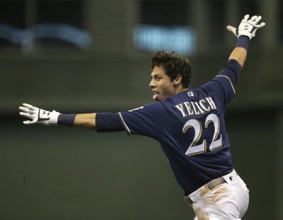 Milwaukee’s Christian Yelich gives the ‘safe’ call as he crosses first base, beating the throw to drive in the game-winning run in the Brewers’ 4-3 win over the Chicago Cubs on Monday in Milwaukee. (Aaron Gash / AP)