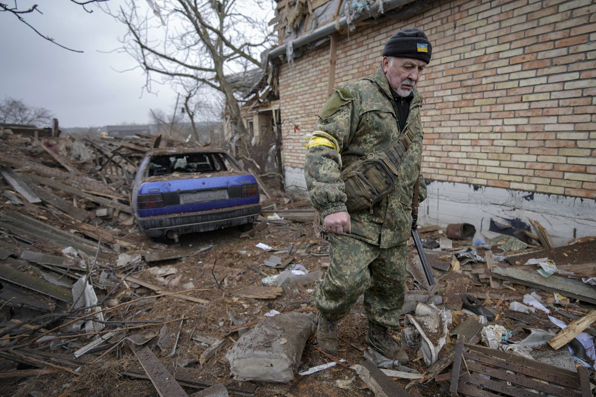 Andrey Goncharuk, 68, a member of territorial defense, walks in the backyard of a house damaged by a Russian airstrike, according to locals, in Gorenka, outside the capital Kyiv, Ukraine, Wednesday, March 2, 2022. Russia renewed its assault on Ukraine