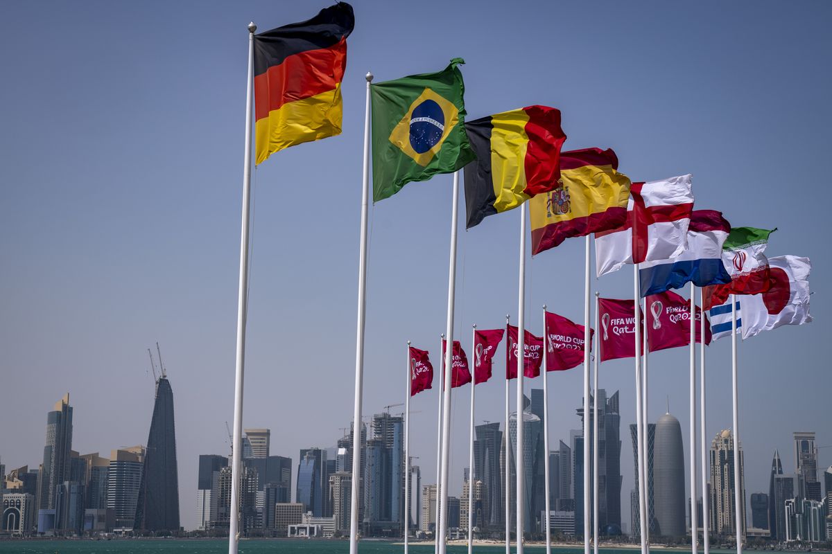 Flags of some of the qualified countries for the World Cup wave at the seafront in Doha, Qatar, Tuesday, March 29, 2022. The draw for the World Cup will be held in Doha on April 1.  (Associated Press)